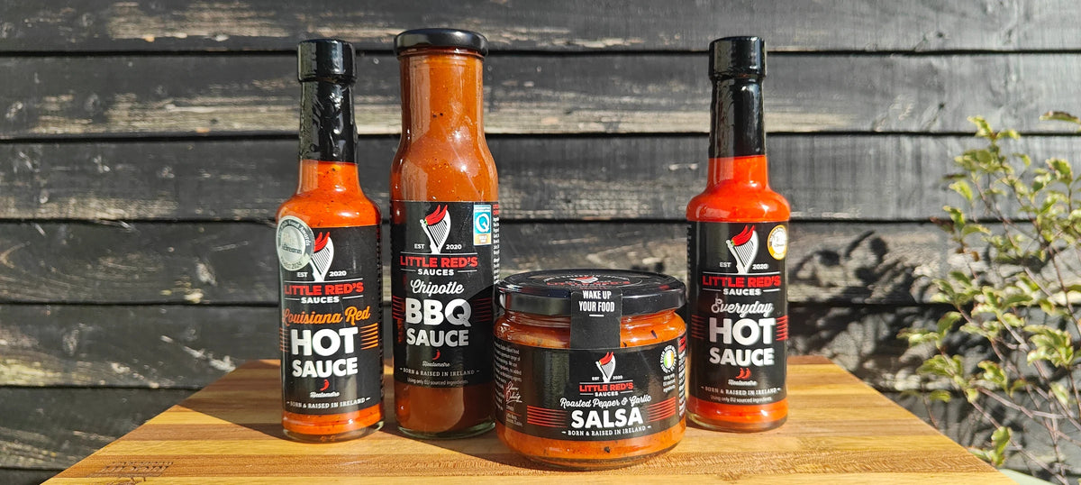 Louisiana Red, Chipotle BBQ, Roasted Pepper & Garlic Salsa and Everyday Hot Sauce on a timber board